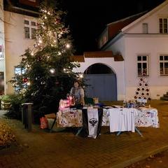 Weihnachtlicher Stand mit Weihnachtsbaum vor dem alten Plauer Rathaus.