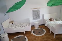 Über den Betten sind Blätter als Himmel angebracht.