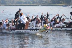 mehrere Drachenboote paddeln gegeneinander