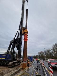 Das Großbohrgerät hat Stellung bezogen und treibt die mächtigen Bohrer dicht am Fahrbahnrand in den Boden.