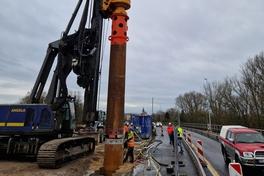 Das Großbohrgerät hat Stellung bezogen und treibt die mächtigen Bohrer dicht am Fahrbahnrand in den Boden.