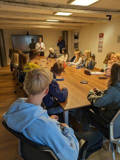 Jugendliche sitzen am Tisch, OB scheller stehend davor