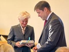 Ein Mann übergibt einer Frau ein Buch als Geschenk.