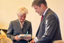 Ein Mann übergibt einer Frau ein Buch als Geschenk.