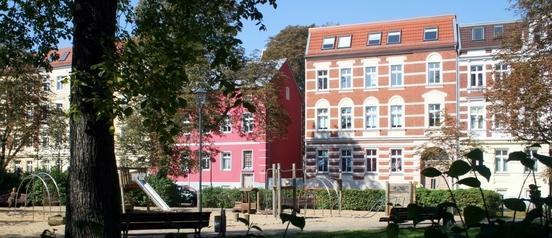 Ein Spielplatz und Wohngebäude im Hintergrund