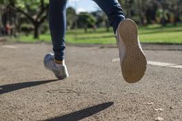 Frau läuft auf Asphalt.