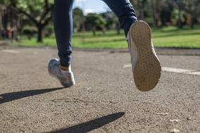 Frau läuft auf Asphalt.