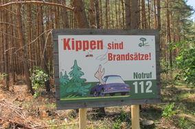Eines der aufgestellten Schilder in einem Wald.