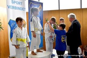 Die Gewinner vom Judoturnier bekommen ihre Medaillen um gehangen.