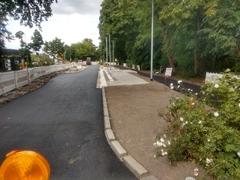 Asphaltierte Straße und Haltestellenbereich