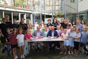 Im Beisein von Kindern und Jugendlichen wurde die Kooperation besiegelt.