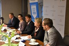 5 Personen sitzen nebeneinander an einem Tisch