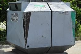 Ein Glascontainer für Grün-und Braunglas steht in der Sonne. Im Hintergrund Bäume.