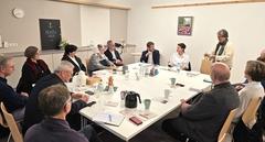 Viele Menschen sitzen am Tisch.