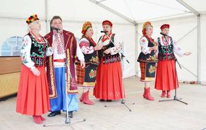 Künstlerensemble in Trachtenkleidung, die ukrainische Folklore und polnische Discomusik präsentieren.