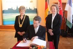 Der neue Ehrenbürger trägt sich in das Goldene Buch der Stadt ein.