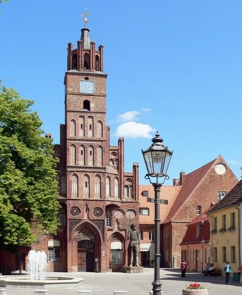 Marktplatz mit grünem Baum und Rathausturm aus rotem Backstein