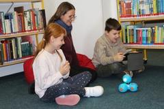 Schüler lassen sich die Funktionsweise von Mini-Robotern erklären.