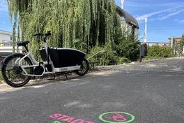 Stadtradel-Logo mit Fahrrad auf dem Radweg am Heinrich-Heine-Ufer.