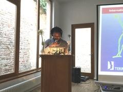 Faith Wagaki Ndege liest aus einem Buch mit Erzählungen geflüchteter Frauen