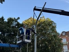 Von einer Hebebühne aus wird der Lichtmast montiert.