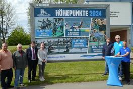 OB und Sportler vor dem Plakat