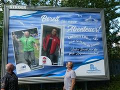 Zwei "Ruheständler" vor ihrem Großplakat
