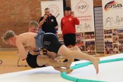 Zwei Sumokämpfer fallen von der Matte.