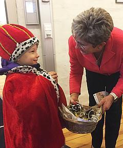 Die Oberbürgermeisterin übergibt Süßigkeiten an einen Sternsinger