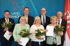 Ministerpräsident Dietmar Woidke (3. von rechts) und Landeswahlleiter Dr. Herbert Trimbach (rechts) mit den fünf ausgezeichneten Ehrenamtlern.