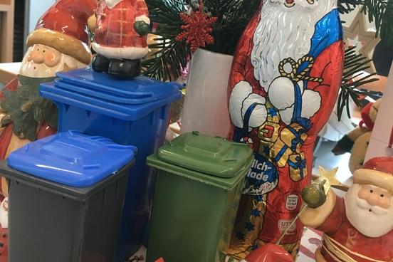 Kleine Abfalltonnen stehen vor Schoko-Weihnachtsmänner