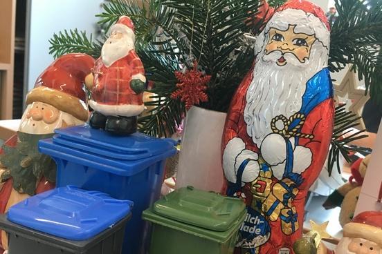 Kleine Abfalltonnen stehen vor Schoko-Weihnachtsmänner