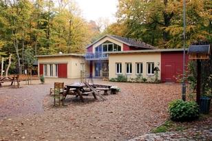 Einstöckiges Gebäude mit Vorhof und von Bäumen umgeben