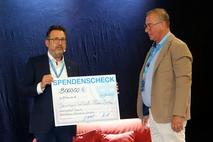 Oliver Windeck überreicht einen neuen Spendenscheck für die Alte Plauer Brücke.