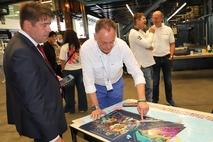 Der Oberbürgermeister sieht sich die hochwertigen Ausdrucke an.