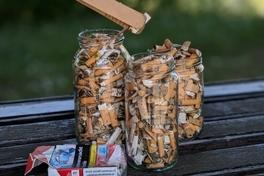 Zigarettenkippen in einem Glas.