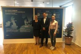 2 Frauen und 1 Mann vor einer Ausstellungswand