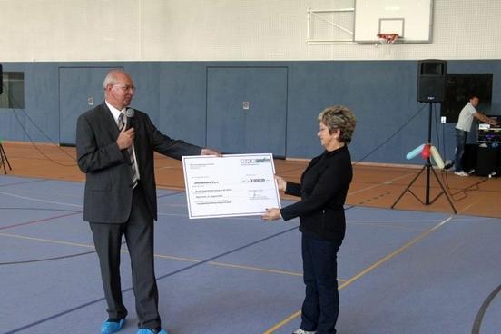 Herr Huismann überreicht der Oberbürgermeisterin einen Spendenscheck i.H.v. 3.000 € für das Fassadenbild der Wilhelm Busch Schule