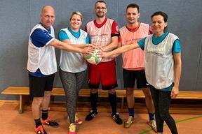 5 Personen klatschen in der Mitte sportlich ab.