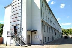 weißes Gebäude mit eingemauertem Aufzugschacht an der Stirnseite