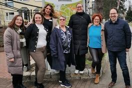 Gruppenbild 7 Personen 6 Frauen 1 Mann vor Schild