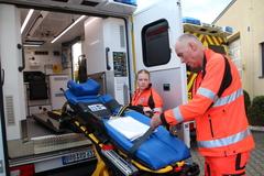 Rettungsdienstmitarbeiter beim Prüfen der Trage.