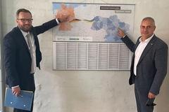 Bürgermeister Müller und sein Amtskollege Reznik zeigen an der Karte wie weit die Entfernung zwischen den beiden Städten ist.