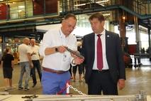 Standortleiter Matthias Rößling erklärt ein Bauteil, dass bei Heidelberg gefertigt wird.