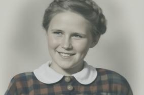 Ursula Wenck als junges Mädchen mit karierten Kleid und geflochtenen Haar.