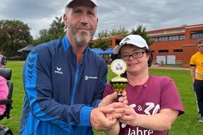 Zwei Teilnehmende halten ihren Pokal in die Kamera.