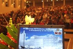Im voll besetzten Theatersaal warten die Gäste auf den Beginn der Festveranstaltung