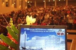 Im voll besetzten Theatersaal warten die Gäste auf den Beginn der Festveranstaltung