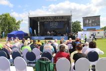 Blick auf die Tribüne mit Leinwand.