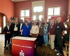 Eine Menschengruppe lächelt in die Kamera